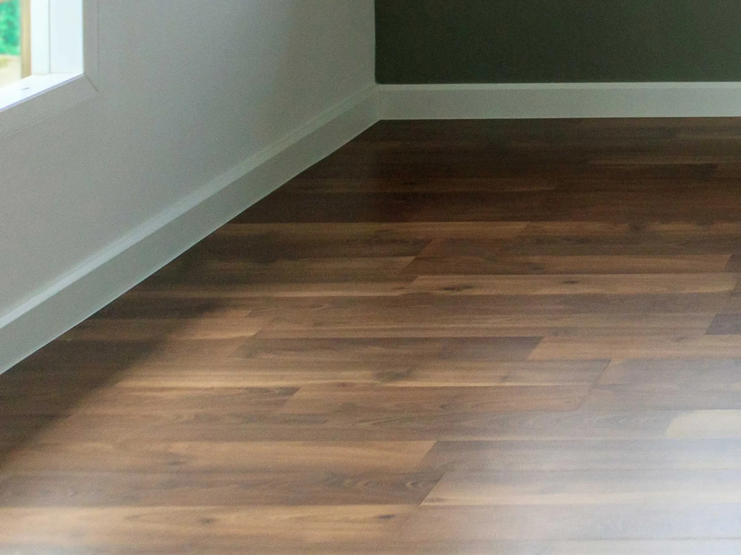 Empty room with dark vinyl flooring.
